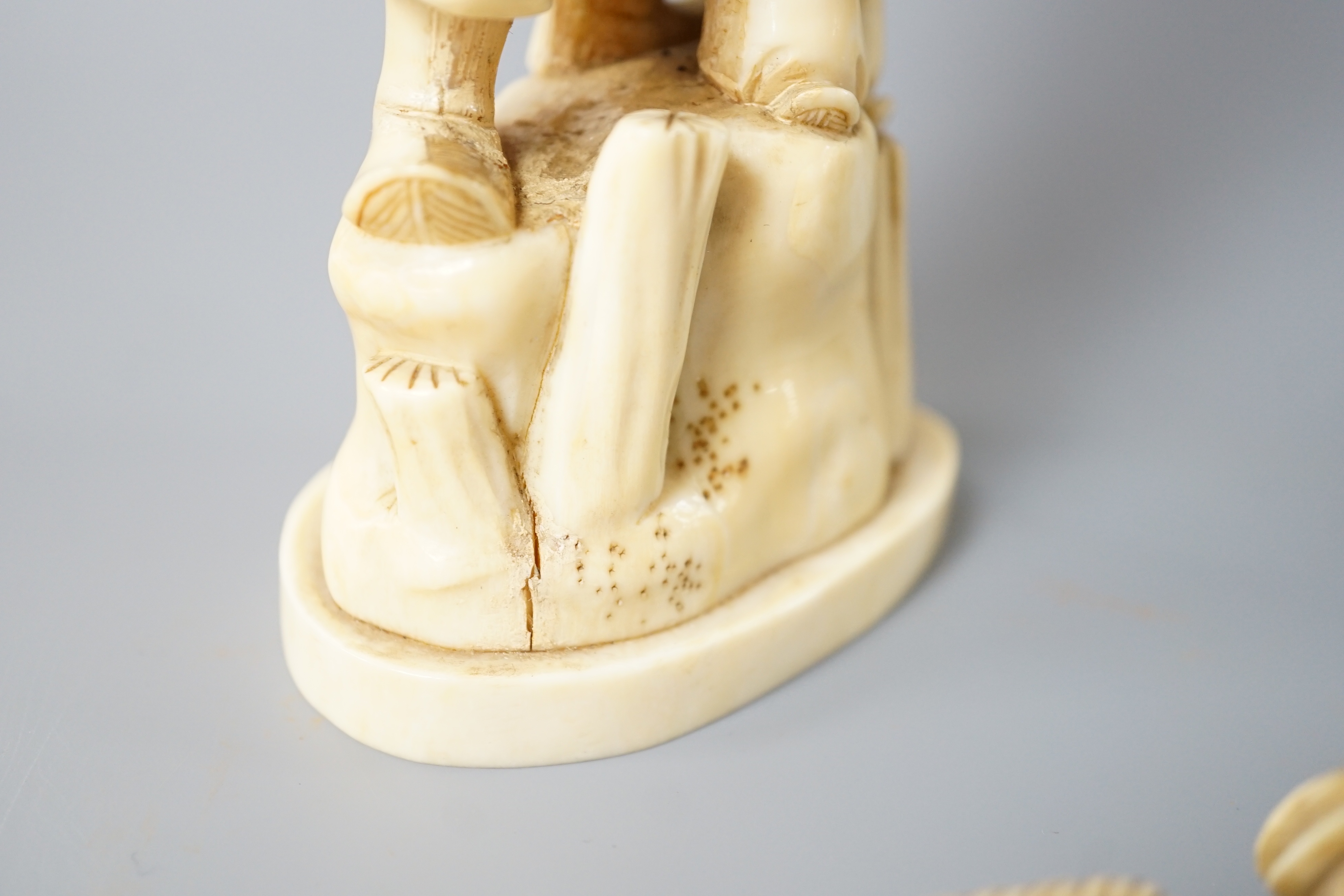 A 19th century Japanese marine ivory okimono of a bearded man and child together with a similar ivory okimono of a mask seller. Tallest 21cm